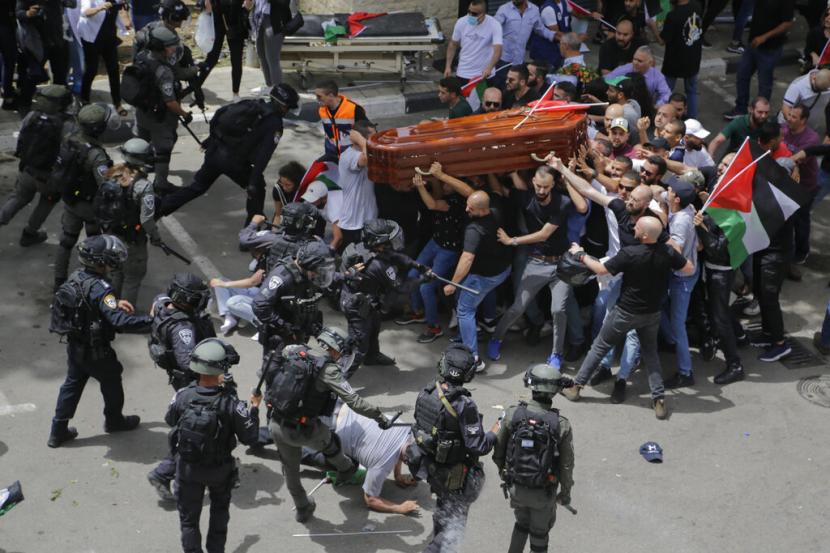 Polisi Israel menyerang pelayat saat mereka membawa peti jenazah jurnalis veteran Aljazirah yang terbunuh Shireen Abu Akleh selama pemakamannya di Yerusalem timur, Jumat, 13 Mei 2022. Musisi Hingga Artis Hollywood Tuntut Israel Tanggung Jawab Pembunuhan Shireen Abu Akleh