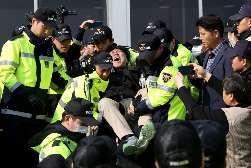 Polisi Korea Selatan mengamankan seorang mahasiswa yang berunjuk rasa menolak kunjungan Presiden Amerika Serikat Donald Trump ke negara itu di depan Majelis Nasional di Seoul, Korea Selatan, Jumat (3/11). Trump akan mengunjungi Korea Selatan pada Selasa (7/11) dan Rabu (8/11). 