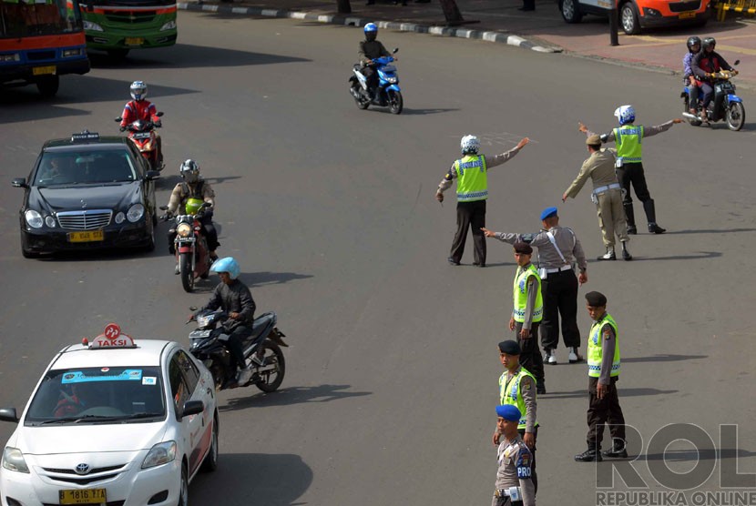  Polisi lalu lintas memberikan arahan pengalihan arus kepada pengguna sepeda motor saat akan melewati ruas jalan MH Thamrin di kawasan Bundaran HI, Jakarta, Rabu (17/12). (Republika/Yasin Habibi)