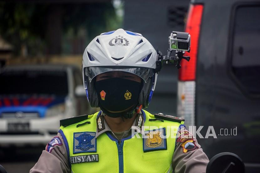Polisi Lalu Lintas menggunakan helm yang dilengkapi kamera portabel pengawas tilang elektronik. 