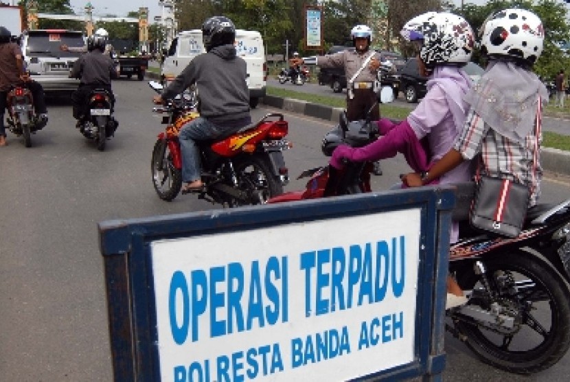  Polisi lalu lintas menghentikan dan memeriksa kelengkapan surat kendaraan ketika berlangsungnya operasi terpadu peningkatan keamanan menjelang pemilukada Aceh di Banda Aceh, NAD.