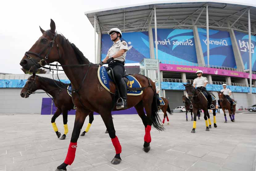 Polisi melakukan patroli dengan menunggang kuda di sekitar stadion utama Asian Games 2014 di Incheon, Korea Selatan, Rabu (17/9). 