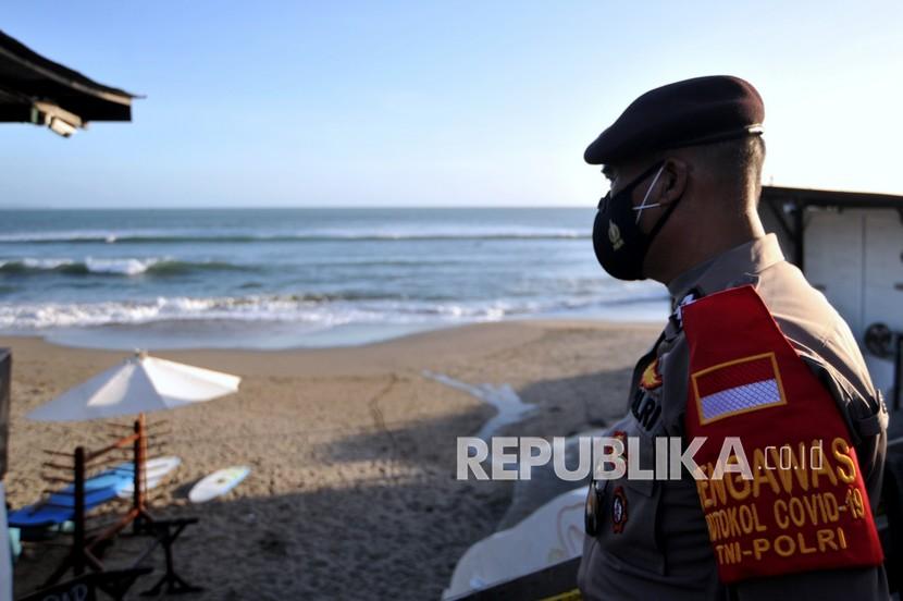 Polisi melakukan pengawasan Pemberlakuan Pembatasan Kegiatan Masyarakat (PPKM) Darurat di objek wisata pantai yang ditutup di kawasan Canggu, Badung, Bali, Ahad (4/7/2021). Pengawasan tersebut dilakukan untuk menertibkan dan membubarkan wisatawan yang tetap berwisata di destinasi pariwisata yang ditutup selama penerapan PPKM Darurat pada 3-20 Juli 2021. 