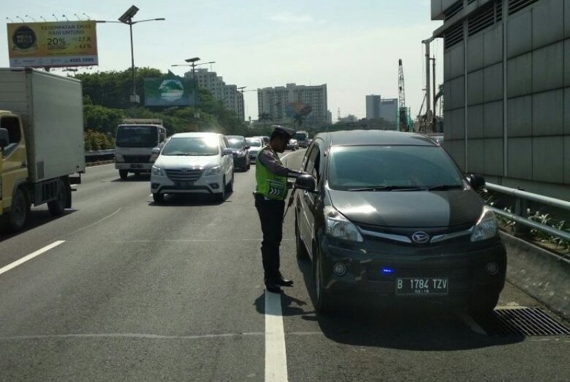 Polisi melakukan penindakan kendaraan yang menggunakan lampu rotator atau sirene di Tol Cawang arah Pancoran, Jakarta Selatan.