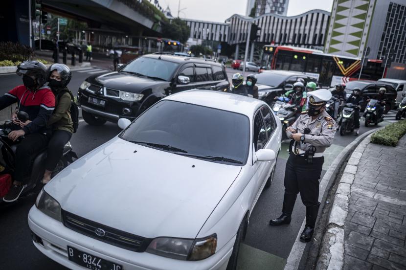 Polisi melakukan penindakan sanksi tilang kepada pengendara mobil yang menggunakan pelat nomor genap di kawasan Jalan Kramat Raya, Jakarta, Senin (13/6/2022). Sistem ganjil genap kembali diberlakukan dan diterapkan di jalan-jalan Jakarta mulai hari ini Rabu (26/4/2023)