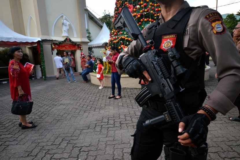 Polisi melakukan penjagaan di halaman gereja katedral jelang misa malam Natal, di Makassar, Sulawesi Selatan.