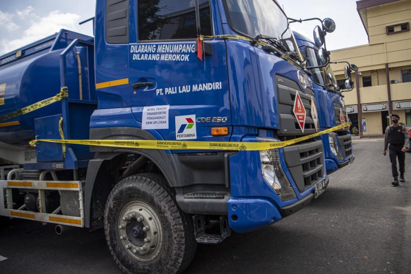 Polisi melintas didepan barang bukti truk tangki pengangkut Bahan Bahan Minyak (BBM) Industri saat ungkap kasus tindak pidana migas (ilustrasi)