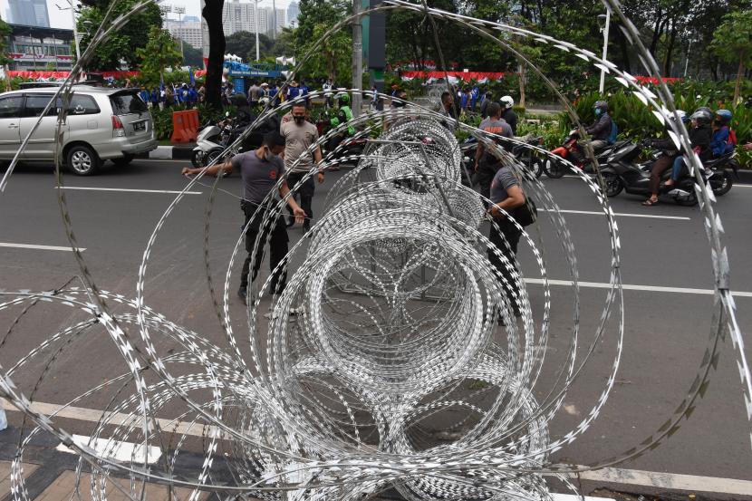 Anggota Direktorat Lalu Lintas Polda Metro Jaya mengalihkan arus lalu lintas kendaraan di sekitar kawasan Istana Merdeka, Jakarta, Kamis (8/10). Ini dilakukan guna mengantisipasi demo buruh menolak Undang-Undang Cipta Kerja.