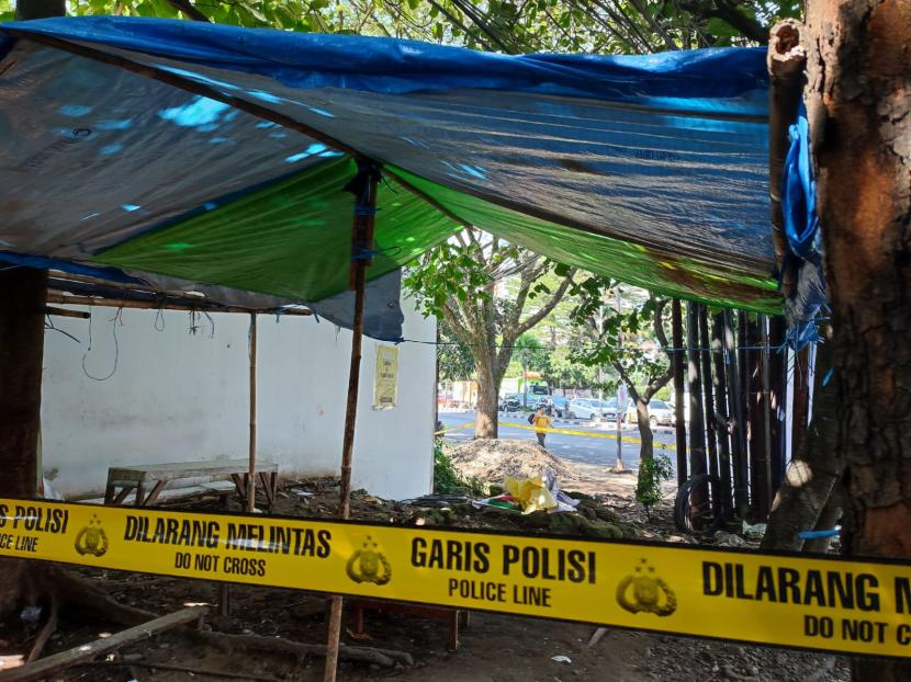 Polisi memasang garis polisi di parit dan lahan yang berada di pinggir Jalan Buahbatu, Kota Bandung dekat RS Mayapada tempat ditemukan jasad pria tanpa identitas, Jumat (12/7/2024). 