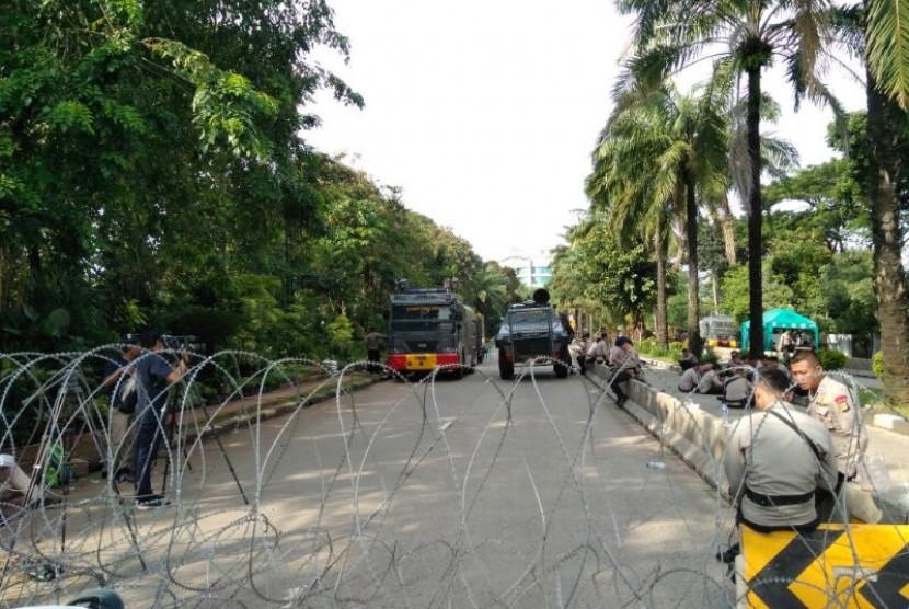 Polisi memasang kawat berduri untuk memisahkan ruas utara dan selatan Jalan Harsono RM, Ragunan, Jakarta Selatan jelang sidang tuntutan terdakwa penistaan agama Basuki Tjahaja Purnama, Selasa (11/4). 