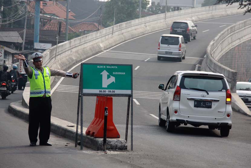 Polisi memasang penutup jalan untuk pemberlakukan satu arah Jalan Layang Non Tol Antasari-Blok M, Jakarta Selatan, Jumat (6/6).