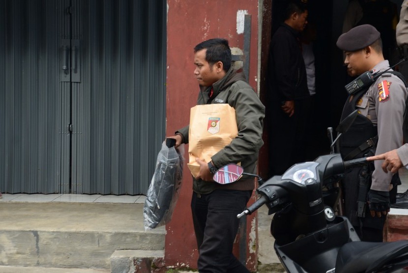 Polisi membawa barang bukti seusai menggeledah rumah kontrakan terduga teroris di Kampung Padasukan, Kecamatan Indihiang, Kota Tasikmalaya, Jawa Barat, Kamis (15/12). 