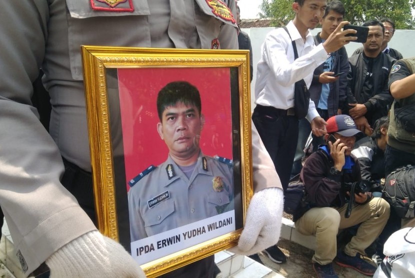 Polisi membawa foto Ipda Erwin Yudha Wildani. Ipda Erwin meninggal dunia usai menderita luka bakar hingga 70 persen, Senin (26/8/2019). Lima pelaku tengah menjalani sidang di PN Cianjur.