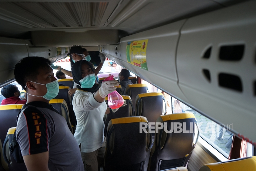 Isolasi bagi pendatang untuk mencegah penyebaran virus di Yogyakarta. cPolisi membersihkan bagian dalam bus di Terminal Jombor, Sleman, D.I Yogyakarta, Ahad (15/3/2020).