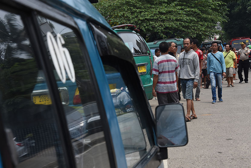 Polisi membubarkan kerumunan sopir angkutan kota (angkot) yang tengah melakukan aksi mogok beroperasi dan diduga akan melakukan sweeping terhadap pengemudi ojek online di Simpangan Depok, Jawa Barat, Selasa (21/3).