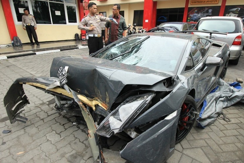 Polisi memeriksa barang bukti mobil Lamborghini yang rusak di Unit Kecelakaan Satuan Lalu Lintas Polrestabes Surabaya, Jawa Timur, Minggu (29/11)