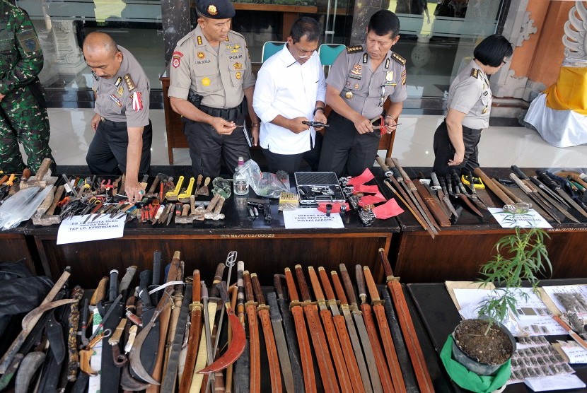 Polisi memeriksa beragam jenis senjata hasil penggeledahan Lembaga Pemasyarakatan (Lapas) Kerobokan, saat gelar barang bukti, di Mapolda Bali, Senin (21/12).