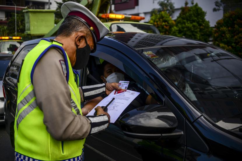 Polisi memeriksa berkas pengendara mobil yang akan menuju Jalan Pangeran Antasari saat melakukan penyekatan di Jalan TB Simatupang, Jakarta.