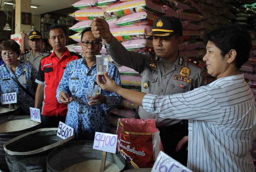 Polisi memeriksa butiran beras di Surabaya, Jawa Timur, Rabu (20/5).