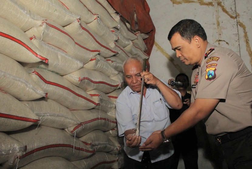 Polisi memeriksa karung beras di pergudangan Kalimas Surabaya, Jawa Timur, Kamis (21/5). 