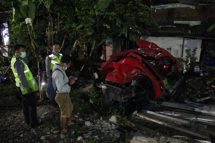 Polisi memeriksa mobil yang tertabrak kereta api di perlintasan kereta api Jalan Manunggal Kebonsari, Surabaya, Jawa Timur, Senin (25/4/2022). Wakil Walkot Armuji meminta perlintasan kereta tanpa palang di Surabaya didata.