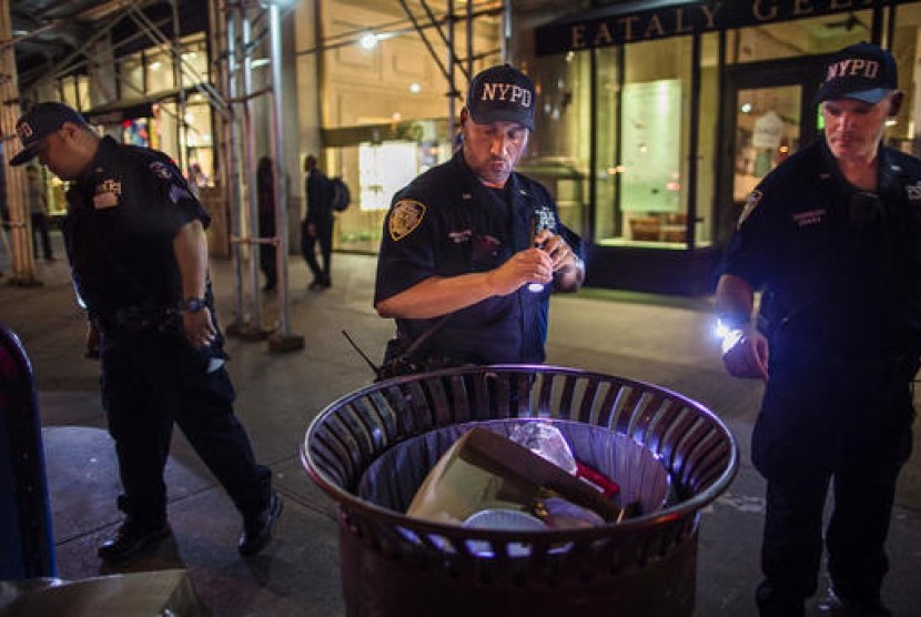 Polisi memeriksa paket mencurigakan di sepanjang Fifth Avenue dekat lokasi ledakan di West 23rd Street dan 6th Avenue di Chelsea, Manhattan, New York, Ahad dini hari waktu setempat.