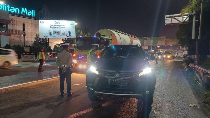 Polisi memeriksa pengendara dengan plat nomor luar kota di GT Tol Bekasi Barat. Kamis (6/5). 