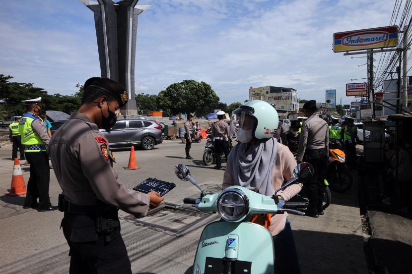 Polisi memeriksa plat kendaraan sepeda motor saat penerapan sistem ganjil genap dalam Pemberlakuan Pembatasan Kegiatan Masyarakat (PPKM) level 3 di kawasan wisata Sentul, Kabupaten Bogor, Jawa Barat, Ahad (28/11). 