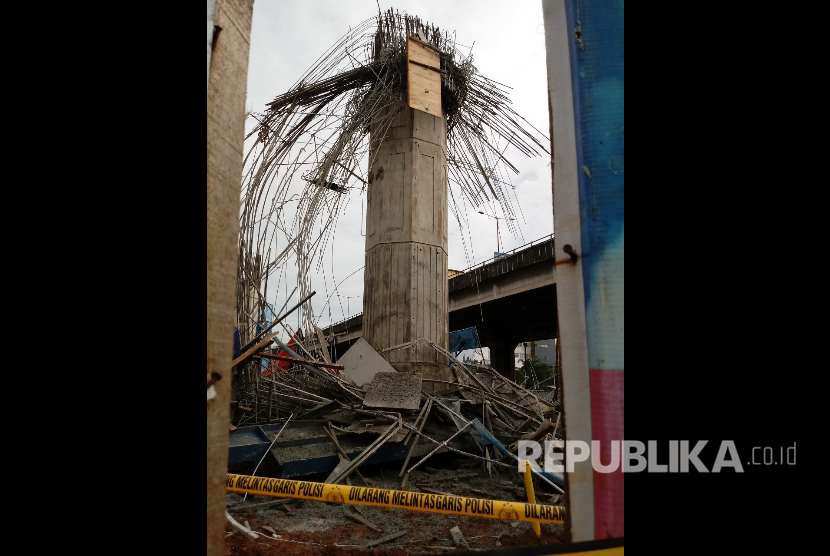 Polisi memeriksa reruntuhan tiang girder proyek Tol Becakayu yang runtuh.