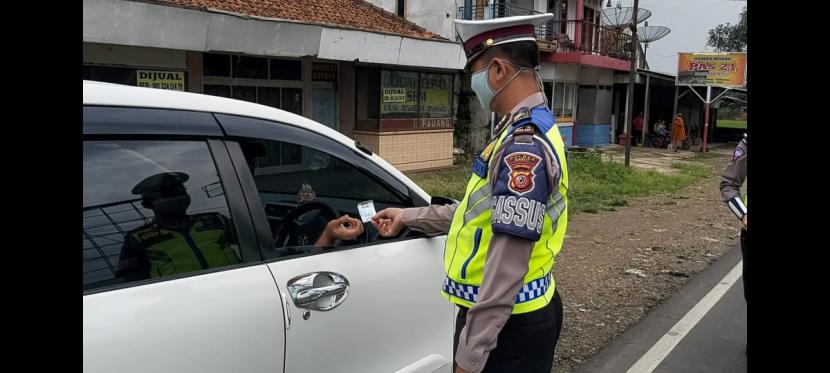 Polisi memeriksa sejumlah kendaraan yang masuk ke wilayah Garut. Jawa Barat, termasuk Garut memberlakukan PSBB untuk cegah Corona. 