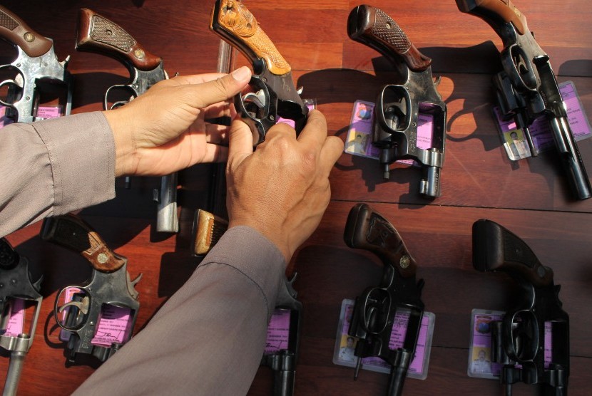 Polisi memeriksa senjata api (senpi) jenis revolver milik anggota Polres Pelabuhan Tanjung Perak Surabaya, Jawa Timur, Jumat (26/6). 