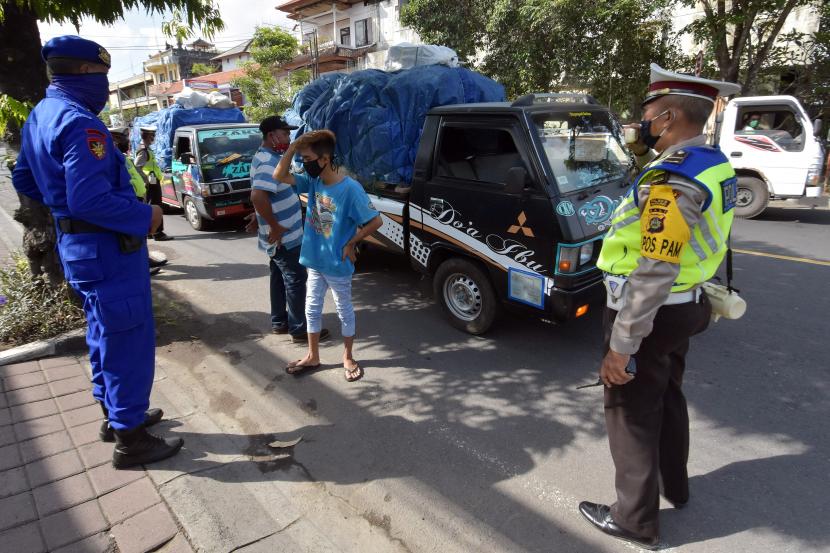 Polisi memeriksa sopir truk barang dalam razia pengamanan dan penyekatan wilayah terdampak COVID-19 di Badung, Bali, Sabtu (2/5/2020). Kegiatan tersebut untuk mengawasi kemungkinan pemudik yang disembunyikan dalam kendaraan angkutan barang menyusul larangan mudik dan penutupan penyeberangan Bali-Jawa karena pandemi COVID-19.