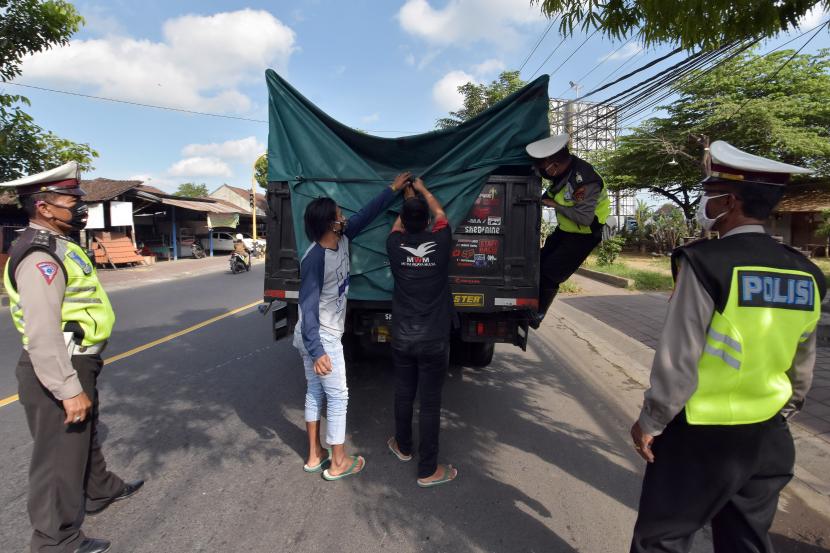 Polisi memeriksa truk barang dalam razia pengamanan dan penyekatan wilayah terdampak COVID-19 di Badung, Bali, Sabtu (2/5/2020). Kegiatan tersebut untuk mengawasi kemungkinan pemudik yang disembunyikan dalam kendaraan angkutan barang menyusul larangan mudik dan penutupan penyeberangan Bali-Jawa karena pandemi COVID-19.