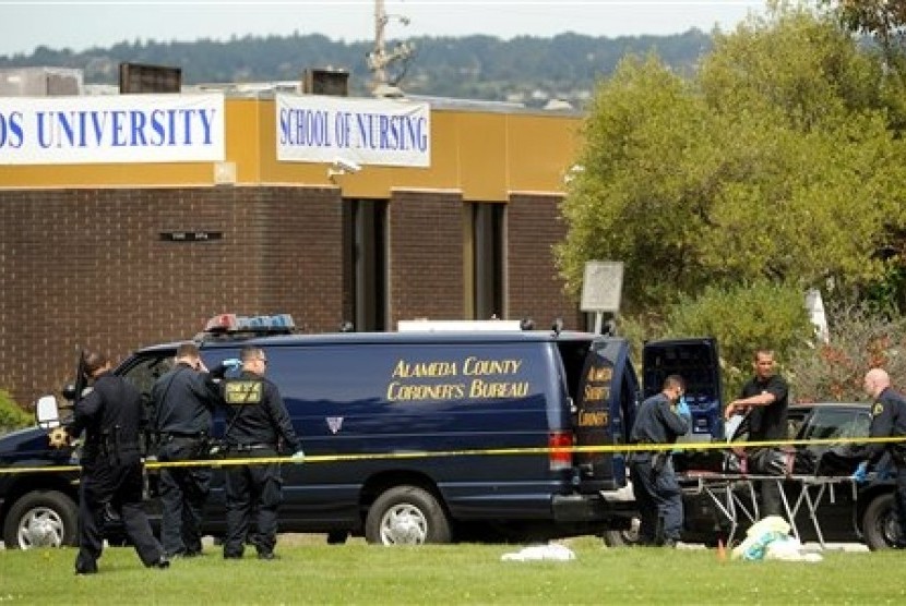  Polisi memindahkan jenazah korban penembakan dari gedung perguruan tinggi swasta keagamaan di Oakland, California, Senin (2/4). (Noah Berger/AP) 