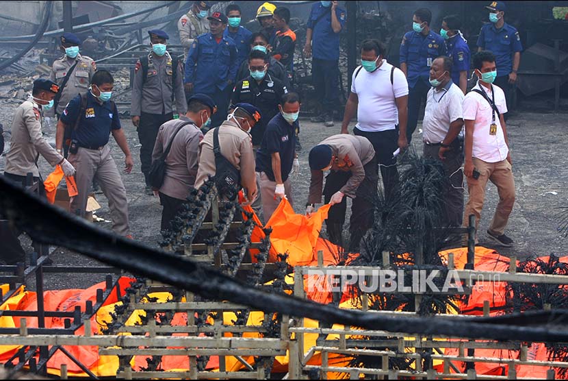 Polisi memindahkan kantong-kantong jenazah ke atas ambulans di lokasi kebakaran Gudang Kosambi, Tangerang