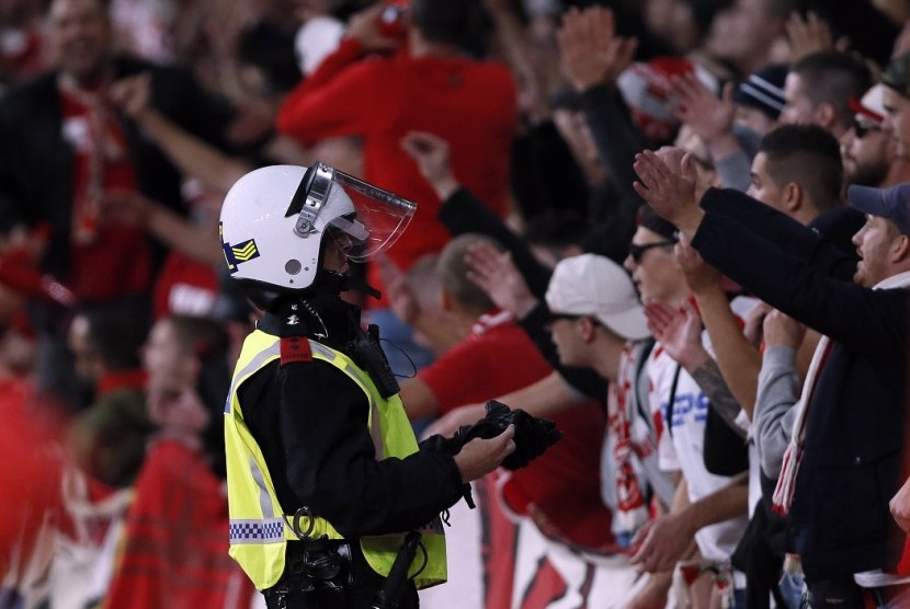 Polisi memperhatikan tindak tanduk pendukung Cologne saat mendukung timnya di Stadion Emirates melawan Arsenal, Jumat (15/9) dini hari WIB.