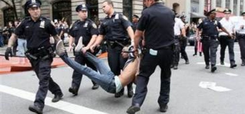 Polisi menahan satu demonstran dalam unjuk rasa anti ketamakan di Wall Street, New York, Sabtu (25/9/2011)