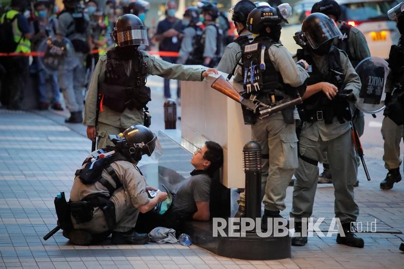Polisi menahan seorang pemrotes dalam pawai yang menandai peringatan penyerahan Hong Kong dari Inggris ke Cina, Rabu, Juli. 1, 2020, di Hong Kong. Hong Kong menandai peringatan 23 tahun penyerahannya ke Cina pada tahun 1997 hanya satu hari setelah Cina memberlakukan undang-undang keamanan nasional yang menindak protes di wilayah tersebut. 