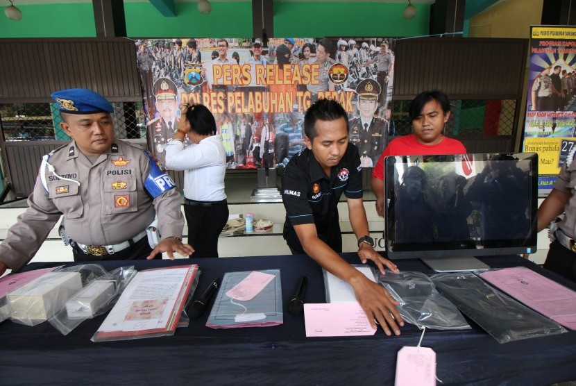 Polisi menata sejumlah barang bukti saat gelar kasus pungutan liar di Polres Pelabuhan Tanjung Perak Surabaya, Jawa Timur, Rabu (2/11).