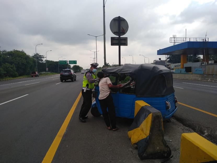 Polisi mencegat bajaj yang dikemudikan Waridin (60 tahun) di tol JORR Km 54, Cakung, Jakarta Timur, Rabu (10/2). Waridin nekat masuk tol JORR dan melaju melawan arah di lajur cepat sejauh 8,5 km.
