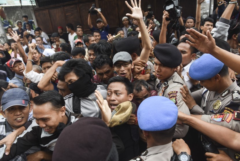 Polisi mendorong warga yang melakukan penghadangan kepada calon Wakil Gubernur DKI Jakarta Djarot Saiful Hidayat saat melakukan blusukan di kawasan Karanganyar, Jakarta, Senin (14/11).