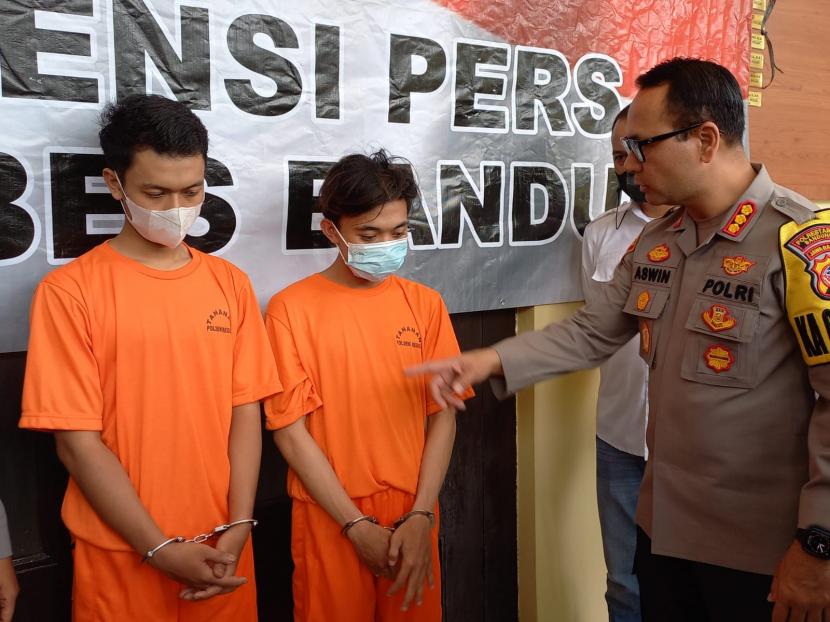 Polisi memperlihatkan dua tersangka kasus penganiayaan dan pencurian terhadap seorang warga di kawasan Pasirluyu, Kota Bandung, saat pengungkapan kasus di Markas Polrestabes Bandung, Senin (2/1/2023).  