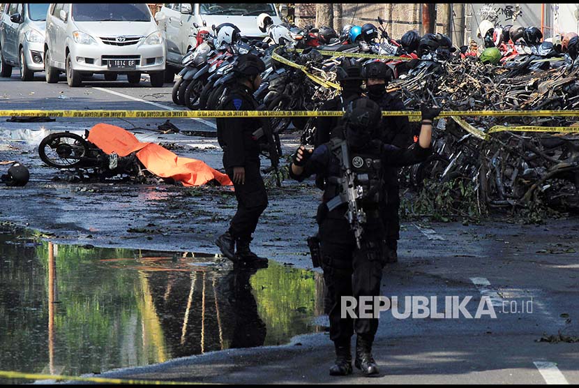 Polisi mengamankan lokasi parkir sepeda motor tempat ledakan bom terjadi di Gereja Pantekosta, Surabaya, Ahad (13/5) 