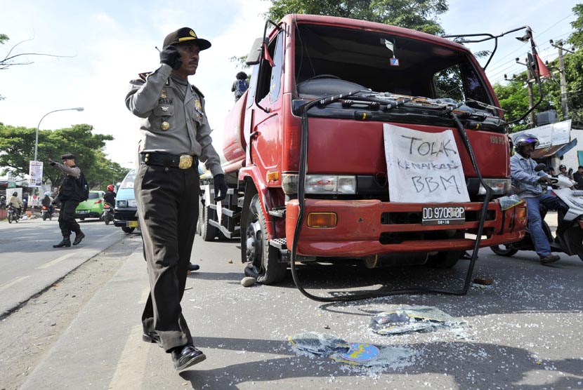  Polisi mengamankan sebuah mobil tangki yang dirusak sejumlah mahasiswa saat berunjuk rasa menentang kenaikan BBM di depan kampus Universitas Muhammadiyah (Unismuh) di Makassar, Sulsel, Rabu (24/4).  (Antara/Yusran Uccang)