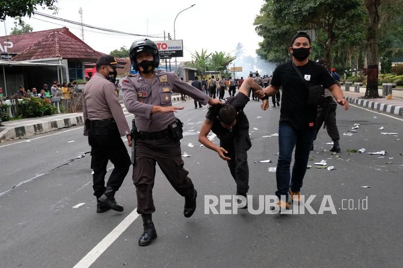 Polisi mengamankan seorang pengunjuk rasa saat demonstrasi menentang Omnibus Law Undang-Undang (UU) Cipta Kerja di Kota Magelang, Jawa Tengah Jumat (9/10/2020). Unjuk rasa tersebut berakhir ricuh dan mengakibatkan sejumlah fasilitas umum rusak. 