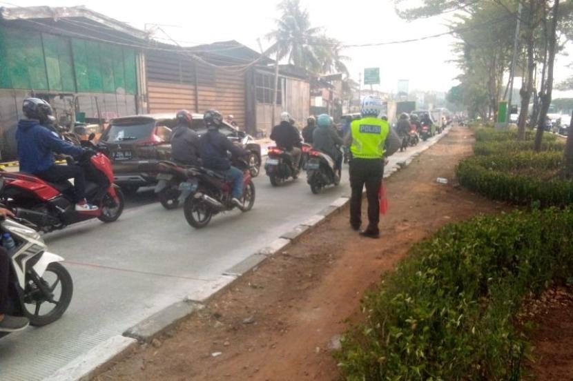Polisi mengatur lalu lintas di Jalan Daan Mogot, Jakarta Barat, yang macet imbas proyek pengerjaan jalan, Jumat (13/10/2023). 