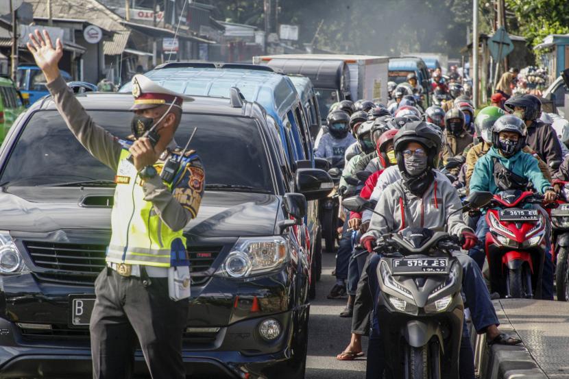Jalur Puncak Buka-Tutup Jelang Tahun Baru. Polisi mengatur lalu lintas kendaraan yang memadati ruas jalan jalur Wisata Puncak, Kabupaten Bogor, Jawa Barat. Ilustrasi