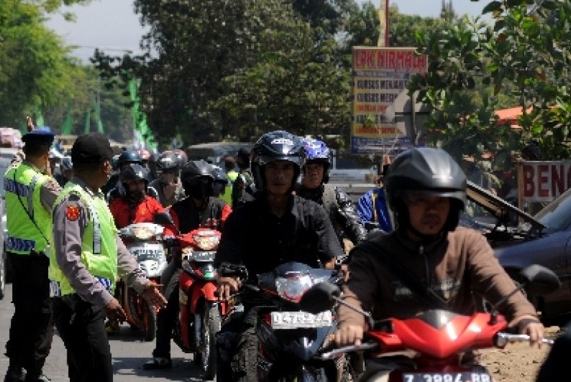 Polisi mengatur lalu lintas pemudik motor untuk menggunakan jalur kiri di kawasan jalur selatan Nagreg, Jawa Barat.