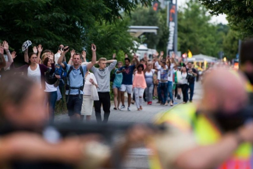 Polisi mengawal evakuasi orang-orang dari pusat perbelanjaan Olympia Einkaufzentrum (OEZ) di Munich, Jerman (22/7), menyusul penembakan di sana. 