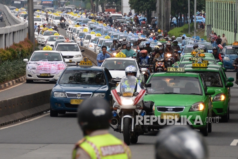 Polisi mengawal ribuan taksi saat meninggalkan aksi di depan DPR, Jakarta, Selasa (22/3).  (Republika/Yasin Habibi)